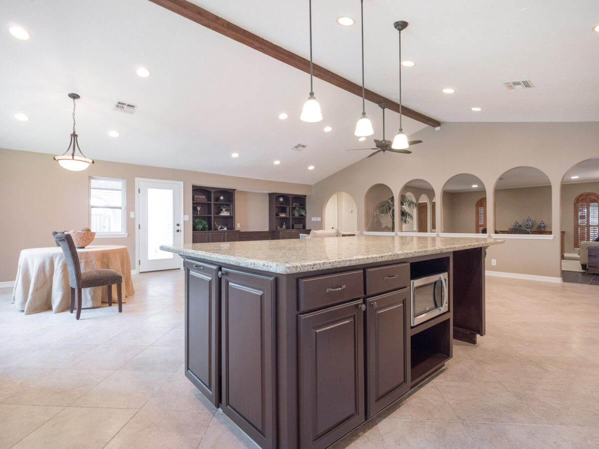A large kitchen with an island and microwave.