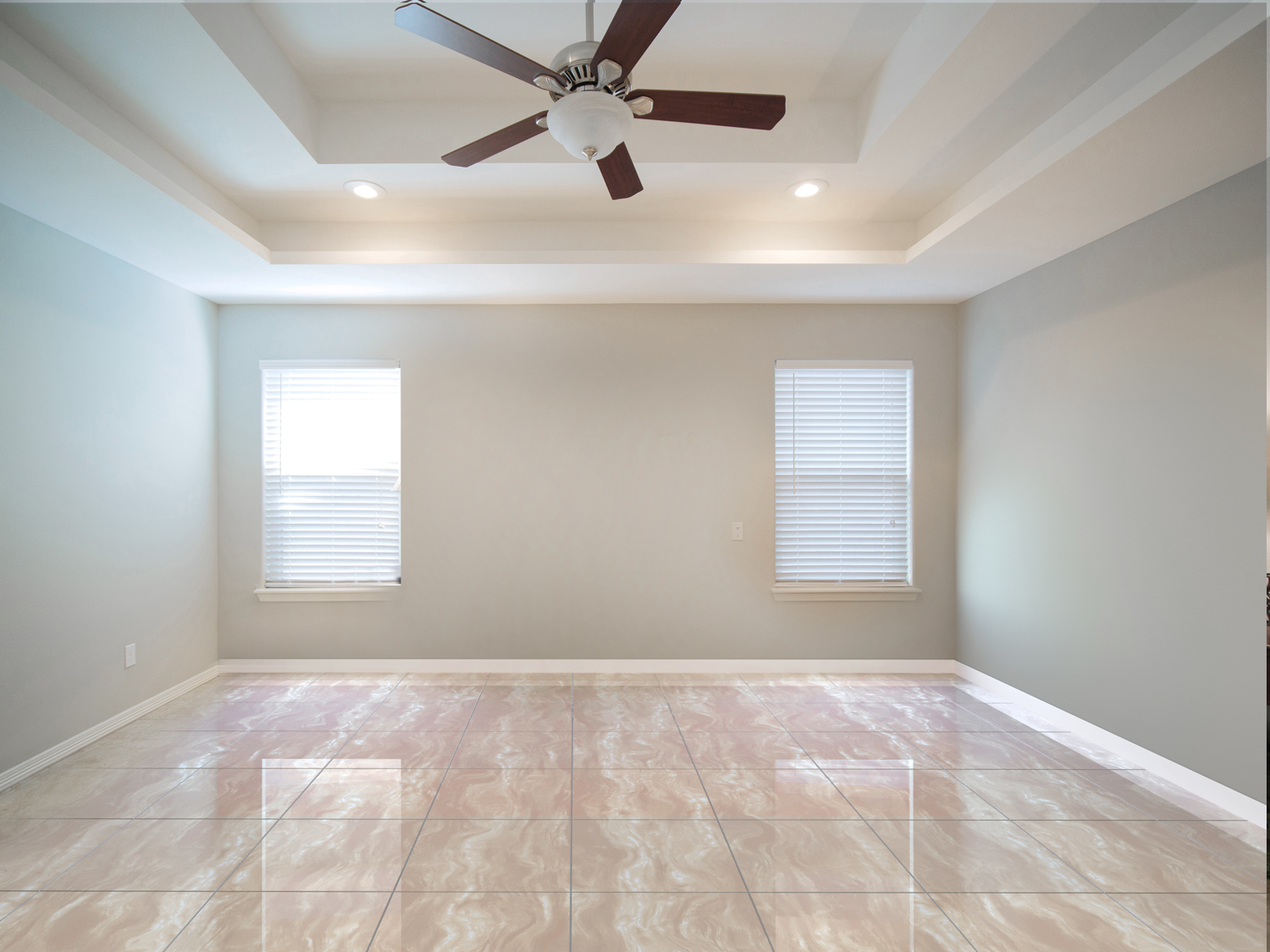 A room with two windows and ceiling fan.