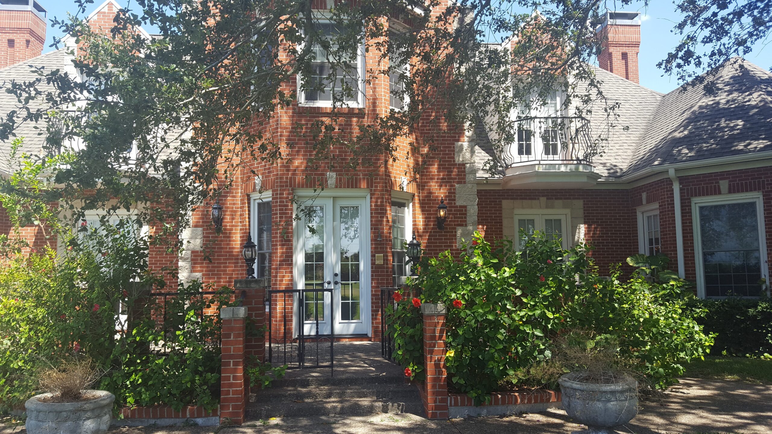 A brick house with a tree in front of it.